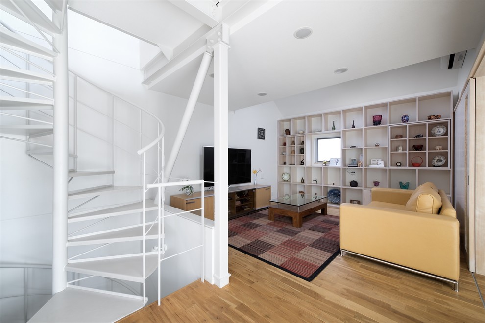 Ejemplo de salón contemporáneo con paredes blancas, suelo de madera en tonos medios, televisor independiente y suelo beige