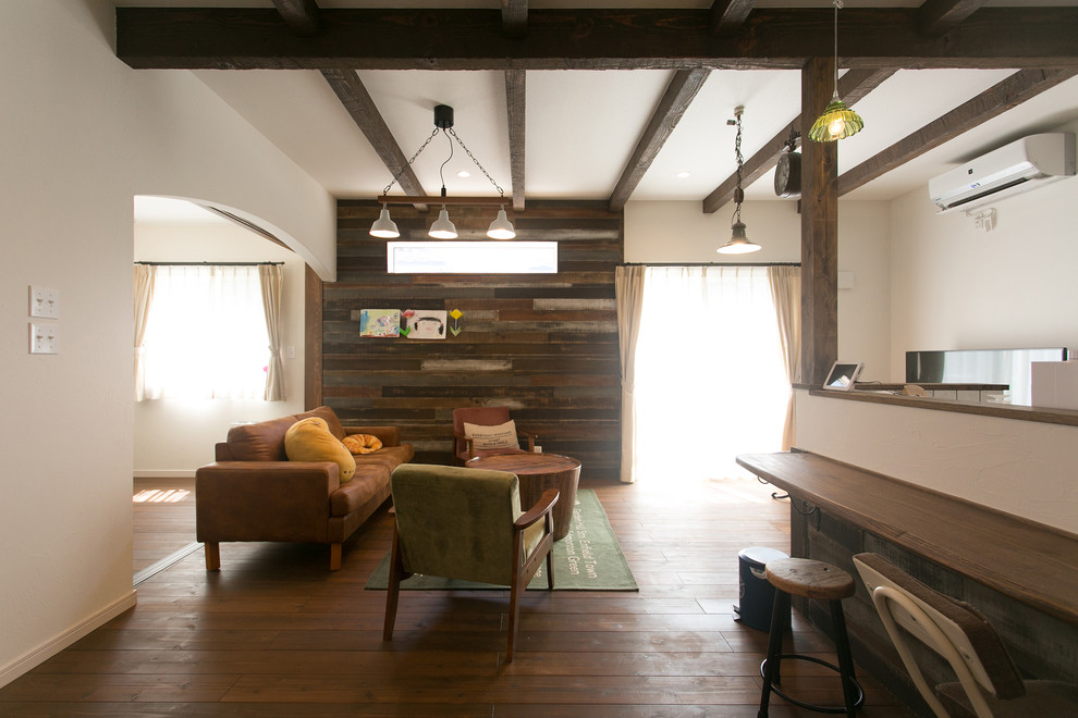 Idee per un soggiorno country con pareti bianche, parquet scuro e pavimento marrone