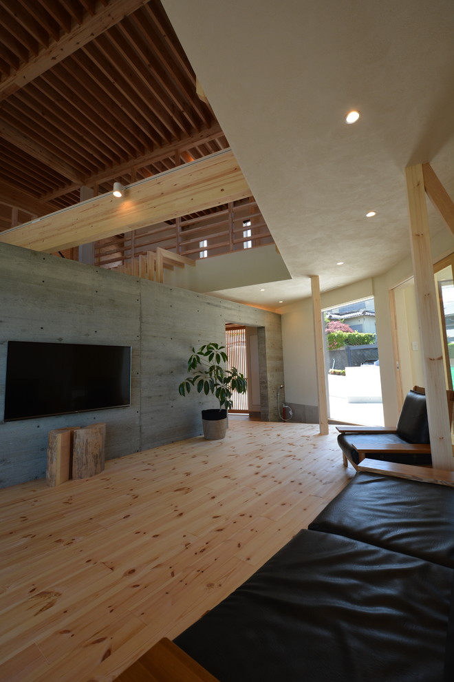 Источник вдохновения для домашнего уюта: открытая гостиная комната с светлым паркетным полом и телевизором на стене