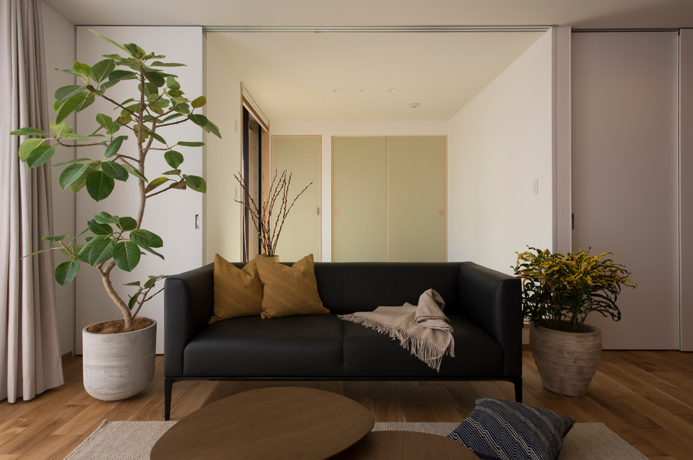 Ispirazione per un soggiorno etnico con pareti bianche, pavimento in legno massello medio e pavimento marrone