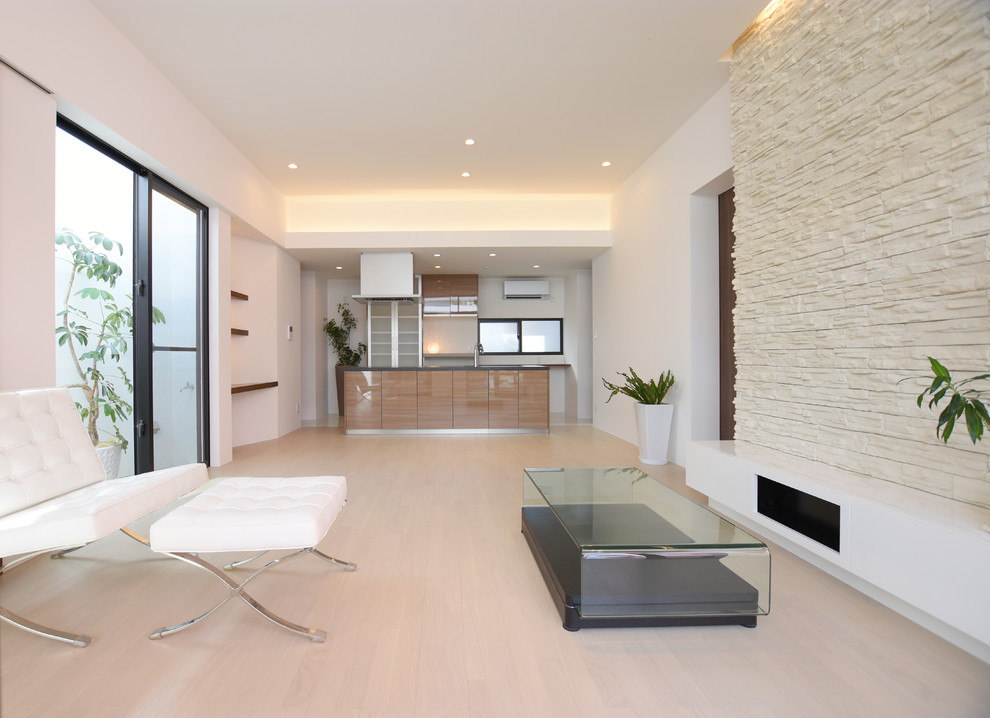 Offenes Modernes Wohnzimmer ohne Kamin mit weißer Wandfarbe, Sperrholzboden, freistehendem TV und weißem Boden in Sonstige