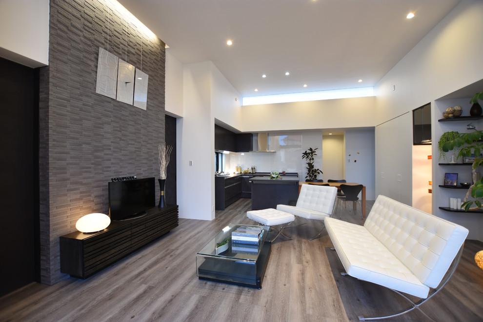 На фото: открытая гостиная комната в стиле модернизм с белыми стенами, полом из фанеры и серым полом без камина