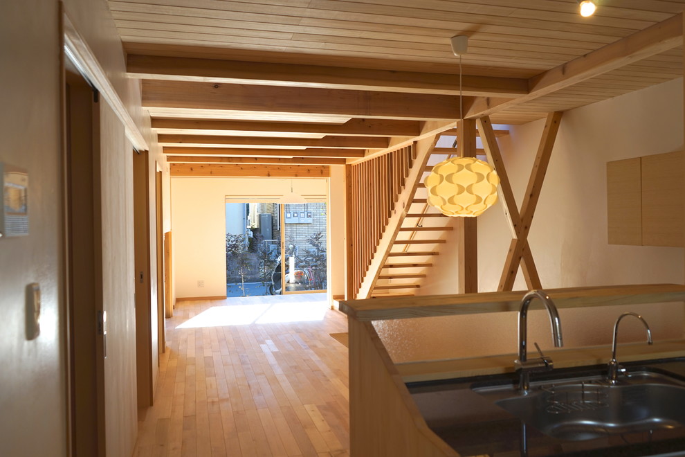 Modelo de salón abierto nórdico pequeño con paredes blancas, suelo de madera clara y suelo beige