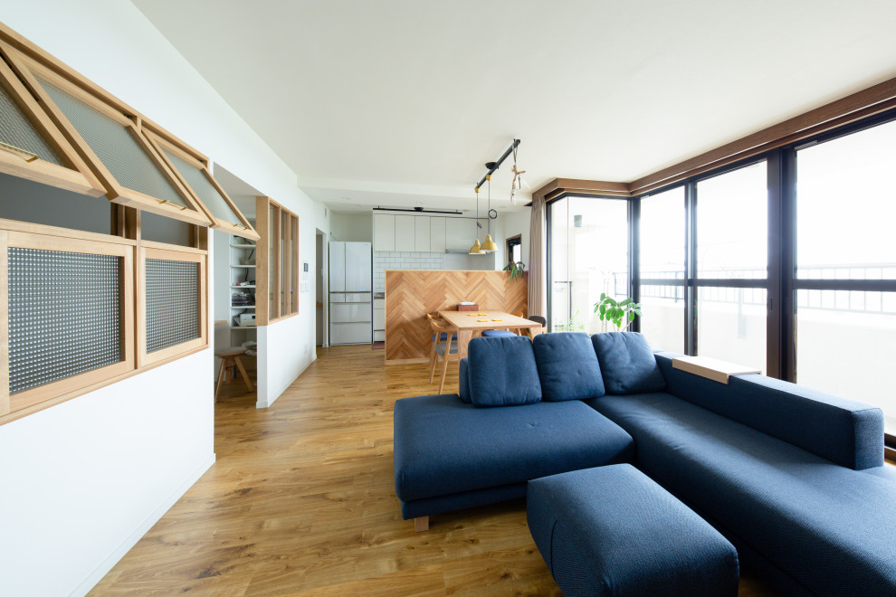 Ejemplo de salón abierto de estilo zen con paredes azules y televisor independiente