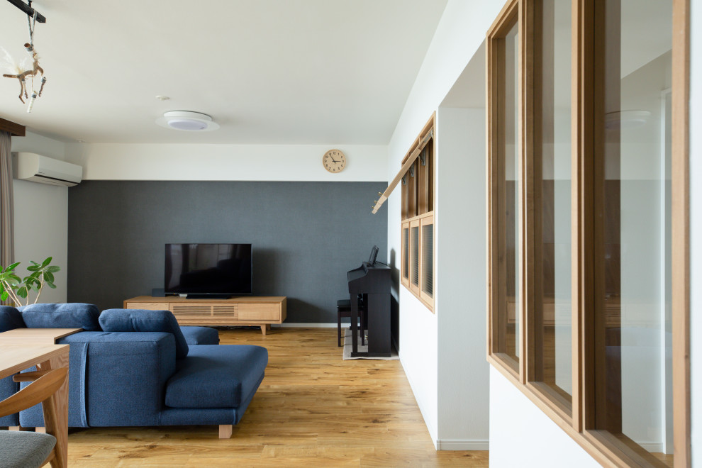 На фото: открытая гостиная комната в восточном стиле с синими стенами и отдельно стоящим телевизором с