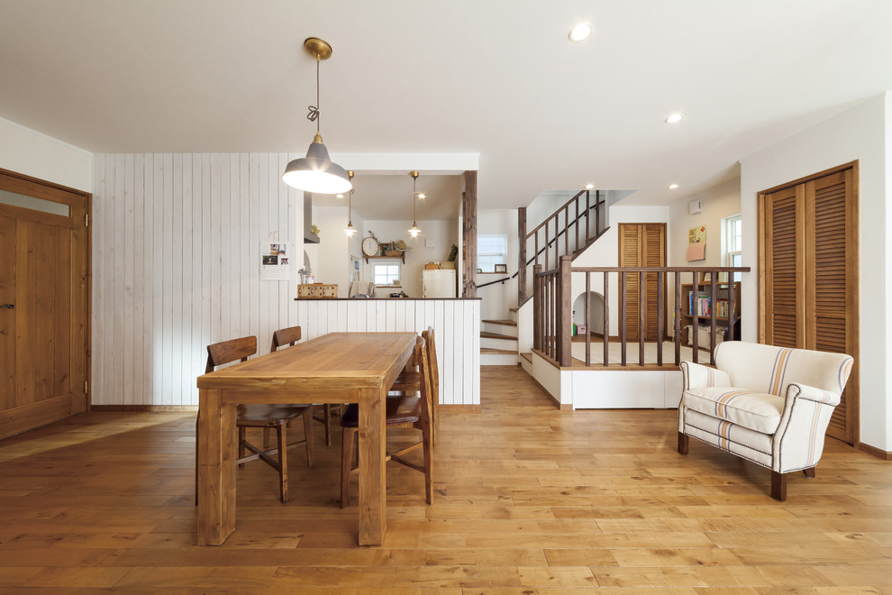Diseño de salón abierto de estilo de casa de campo de tamaño medio con paredes blancas, suelo de madera en tonos medios, televisor independiente y suelo marrón