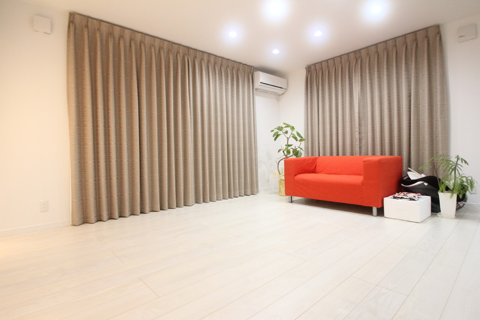 Idée de décoration pour un salon chalet avec un mur blanc, un sol en contreplaqué et un sol blanc.