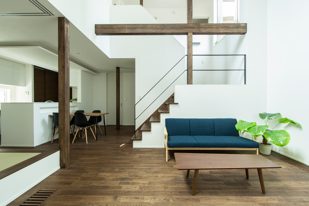 Modelo de salón minimalista con paredes blancas y suelo de madera en tonos medios