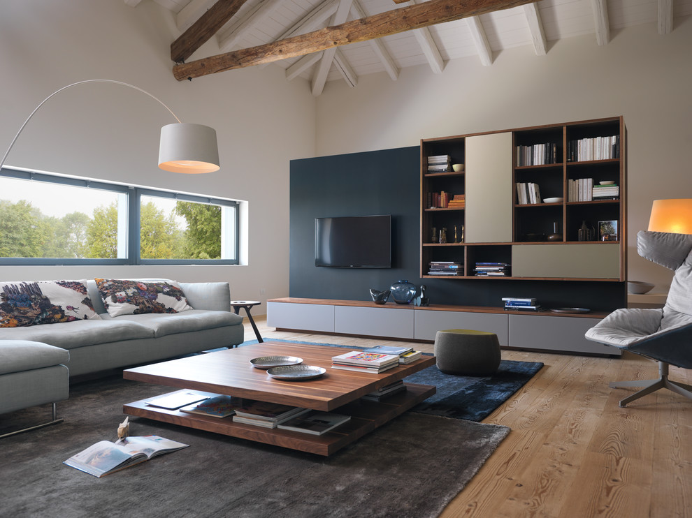 Idéer för ett lantligt vardagsrum, med en väggmonterad TV, vita väggar, mellanmörkt trägolv och brunt golv