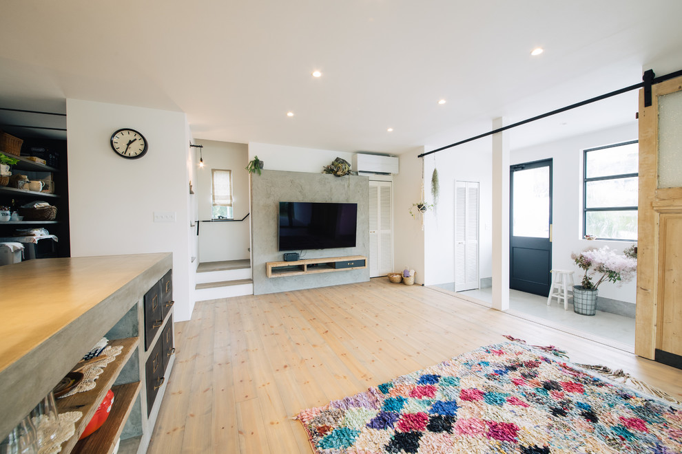 Idee per un soggiorno country aperto con pareti bianche, pavimento in legno massello medio e TV a parete