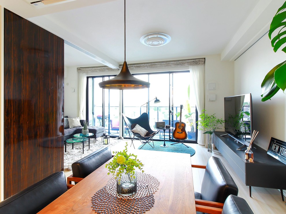 Пример оригинального дизайна: открытая гостиная комната в современном стиле с белыми стенами, деревянным полом, бежевым полом и отдельно стоящим телевизором