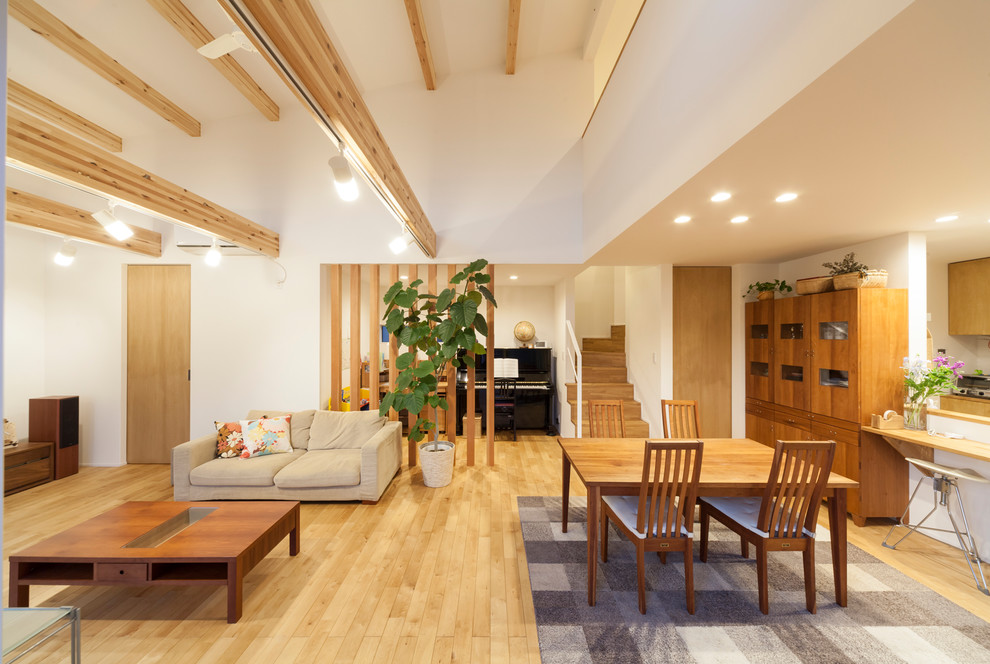 Стильный дизайн: гостиная комната в скандинавском стиле с белыми стенами и коричневым полом - последний тренд