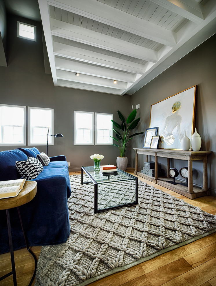 Idée de décoration pour un salon design avec un mur gris, un sol en bois brun et un sol marron.