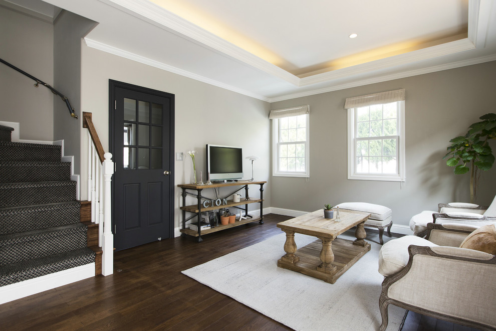 Идея дизайна: гостиная комната в стиле кантри с серыми стенами, темным паркетным полом, отдельно стоящим телевизором и коричневым полом