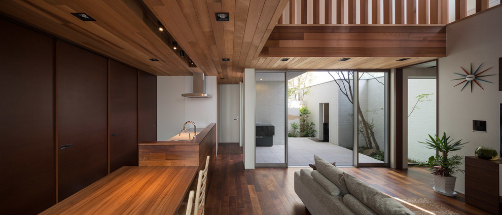 На фото: гостиная комната в стиле модернизм с белыми стенами, паркетным полом среднего тона и коричневым полом с