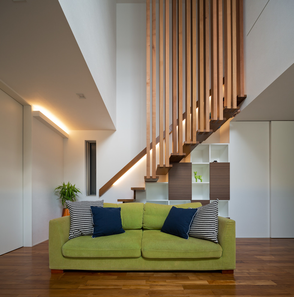 Diseño de salón para visitas moderno sin chimenea y televisor con paredes blancas, suelo de madera en tonos medios y suelo marrón