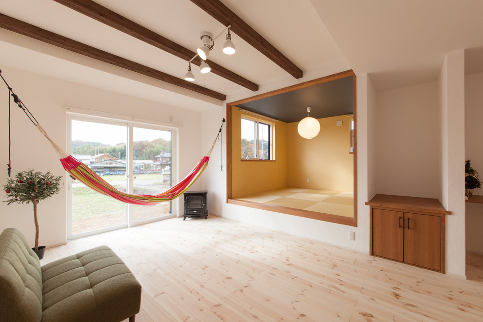 Imagen de salón contemporáneo con paredes blancas, suelo de madera clara y estufa de leña