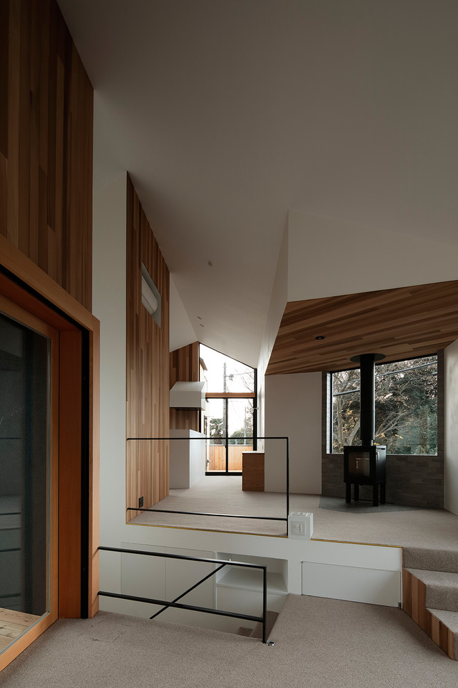 Idées déco pour un salon moderne ouvert avec moquette, un poêle à bois et un manteau de cheminée en carrelage.