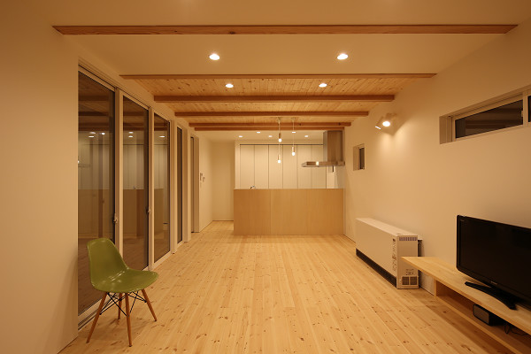 Foto de salón abierto de tamaño medio con paredes blancas, suelo de madera clara, televisor independiente y suelo beige