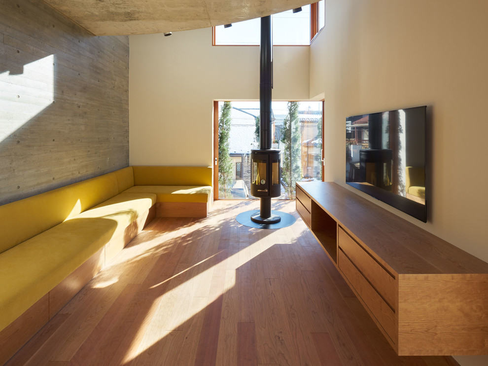 Idéer för ett modernt vardagsrum, med beige väggar, mellanmörkt trägolv, en hängande öppen spis, en väggmonterad TV och brunt golv