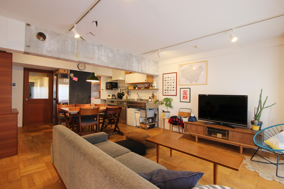 Offenes Asiatisches Wohnzimmer mit weißer Wandfarbe, braunem Holzboden, freistehendem TV und braunem Boden in Tokio