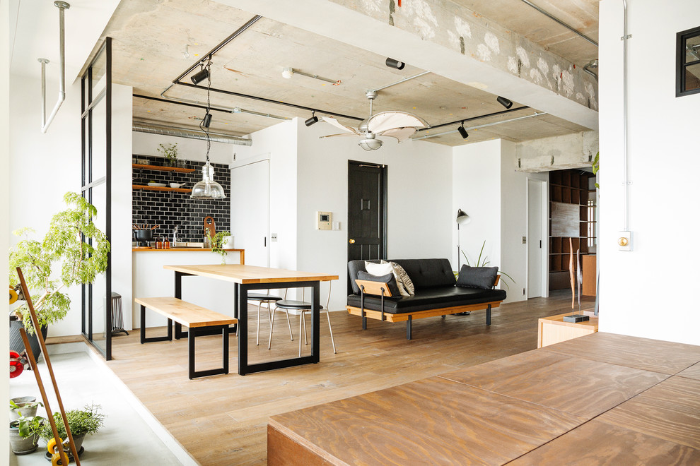 Foto de salón abierto industrial con paredes blancas y suelo de madera en tonos medios