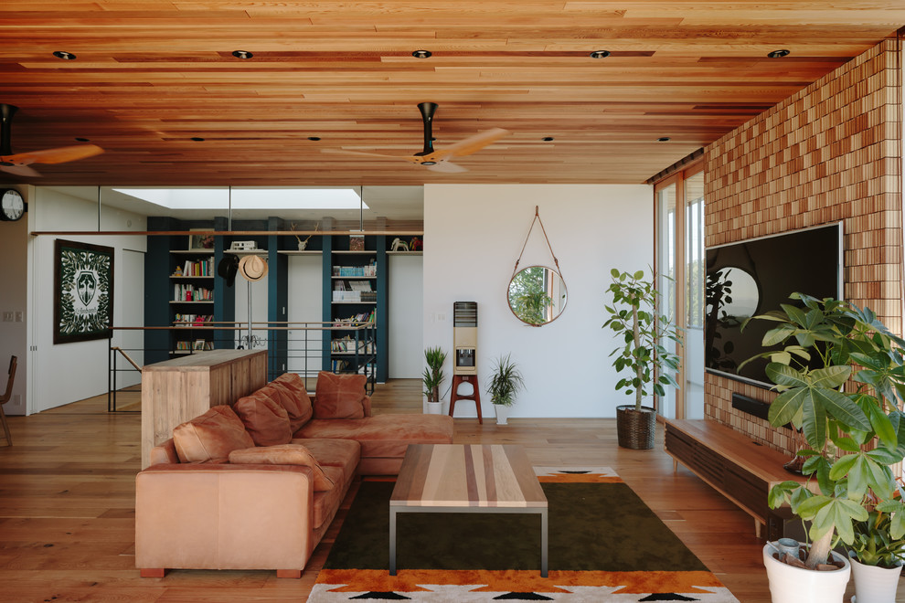 Ejemplo de salón cerrado vintage con paredes blancas, suelo de madera en tonos medios, televisor colgado en la pared y suelo marrón