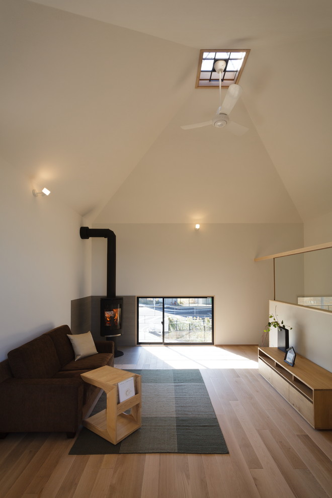 На фото: гостиная комната в скандинавском стиле с белыми стенами, паркетным полом среднего тона и бежевым полом с