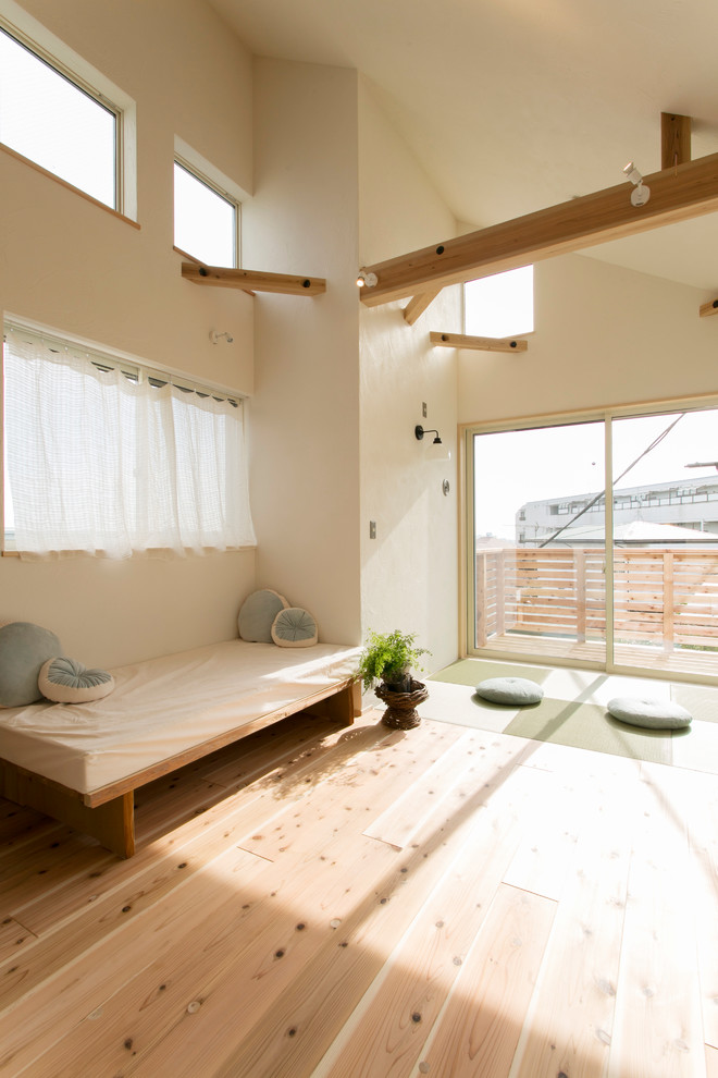 На фото: гостиная комната в восточном стиле с белыми стенами, светлым паркетным полом и коричневым полом