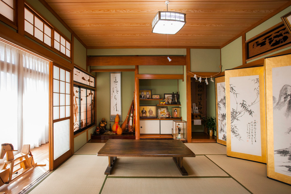 Réalisation d'un salon asiatique fermé avec une salle de réception, un mur vert, un sol de tatami, aucune cheminée, aucun téléviseur et un sol beige.