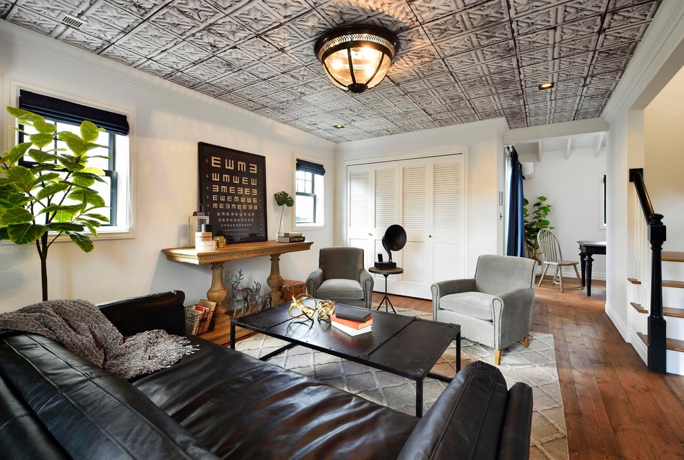 Ispirazione per un soggiorno chic con pareti bianche, pavimento in legno massello medio e pavimento marrone