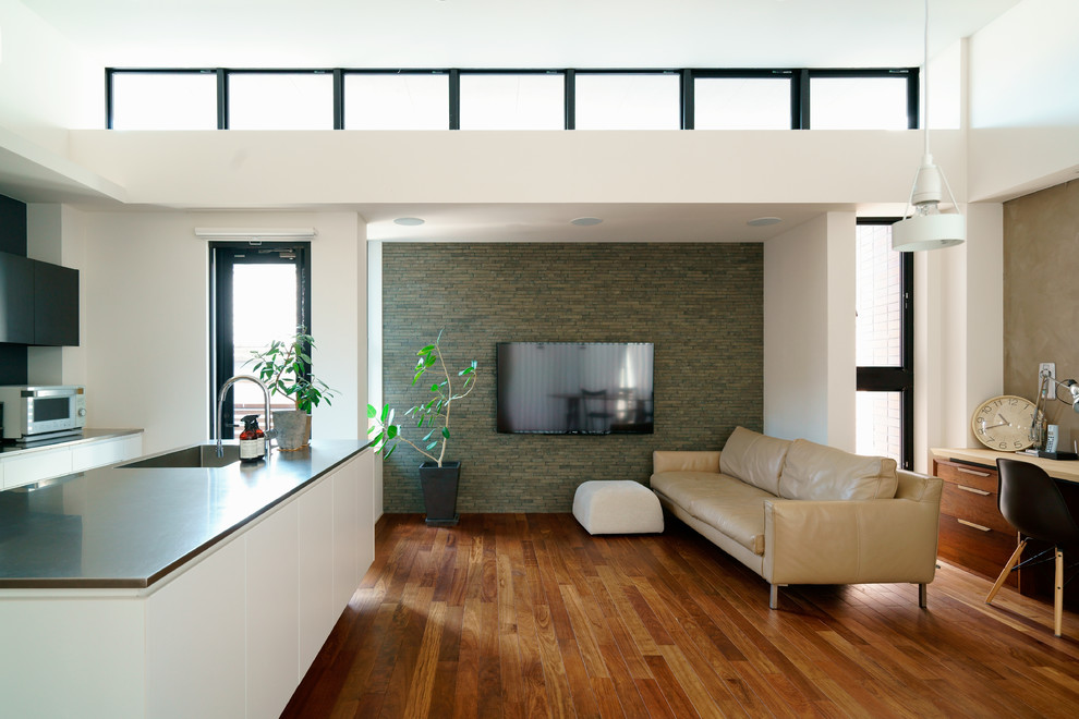 Cette photo montre un salon tendance ouvert avec un mur multicolore, un sol en bois brun, un téléviseur fixé au mur et un sol marron.