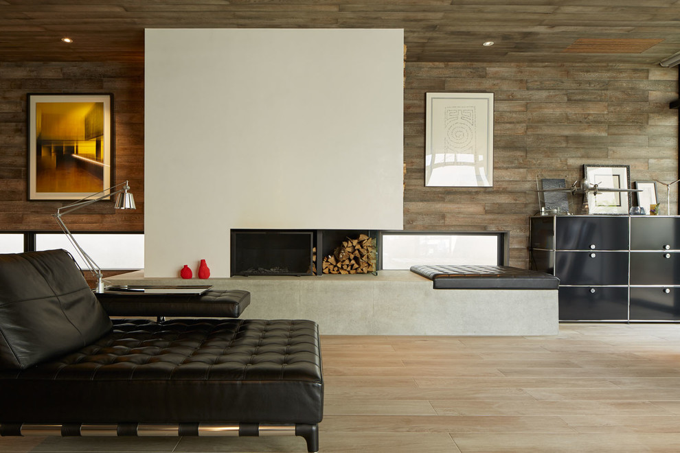 Foto de salón actual con suelo de madera clara, marco de chimenea de hormigón, chimenea lineal y paredes beige