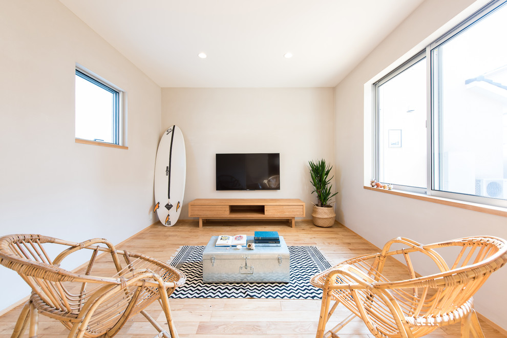 Idée de décoration pour un salon nordique avec un mur blanc, parquet clair, un téléviseur fixé au mur et un sol marron.