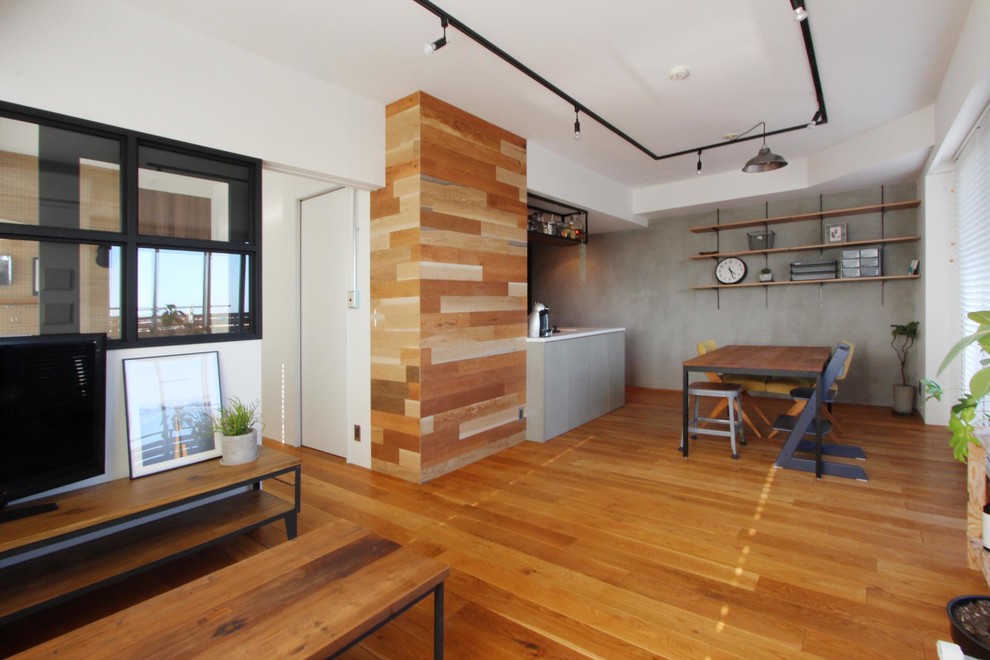 Immagine di un soggiorno etnico aperto con pareti bianche, pavimento in legno massello medio e TV autoportante