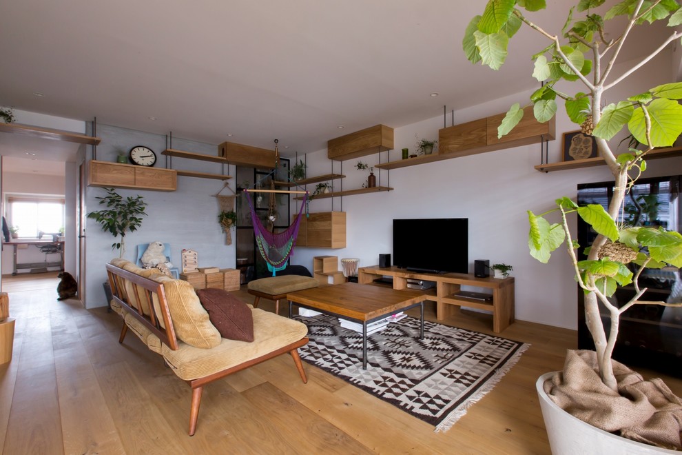 Ejemplo de salón abierto rústico de tamaño medio con paredes blancas, suelo de madera en tonos medios, televisor independiente y suelo beige