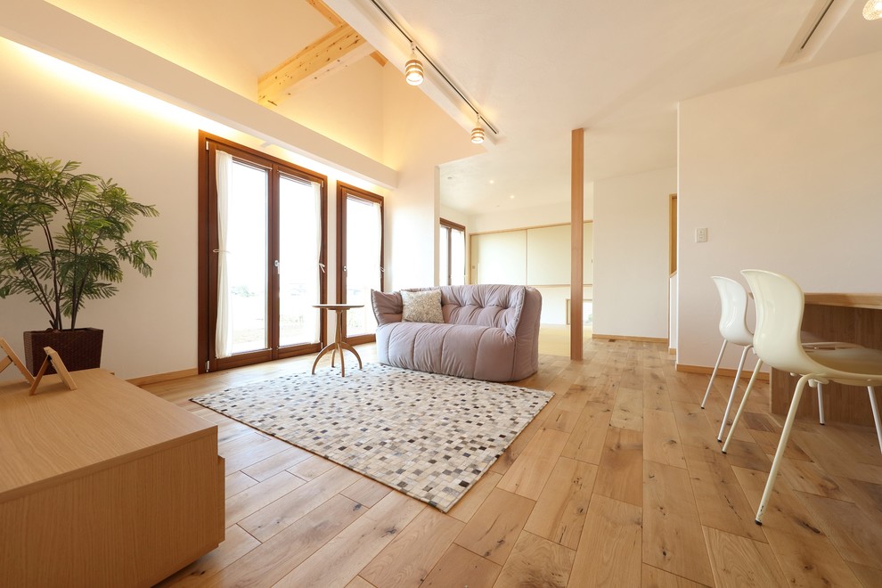 Foto på ett medelhavsstil allrum med öppen planlösning, med vita väggar, mellanmörkt trägolv, brunt golv, ett finrum och en fristående TV