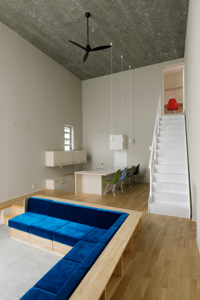 Свежая идея для дизайна: открытая гостиная комната среднего размера в стиле лофт с серыми стенами, светлым паркетным полом, обоями на стенах и синим диваном без камина, телевизора - отличное фото интерьера