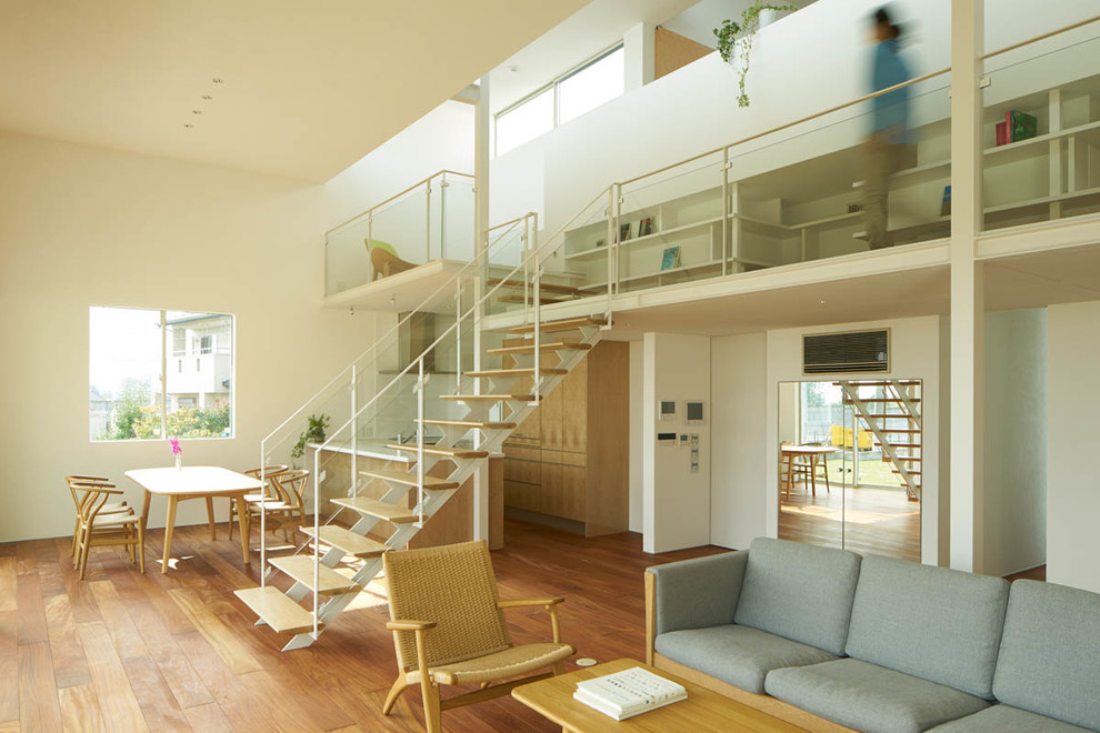 Modernes Wohnzimmer mit weißer Wandfarbe und braunem Holzboden in Sonstige