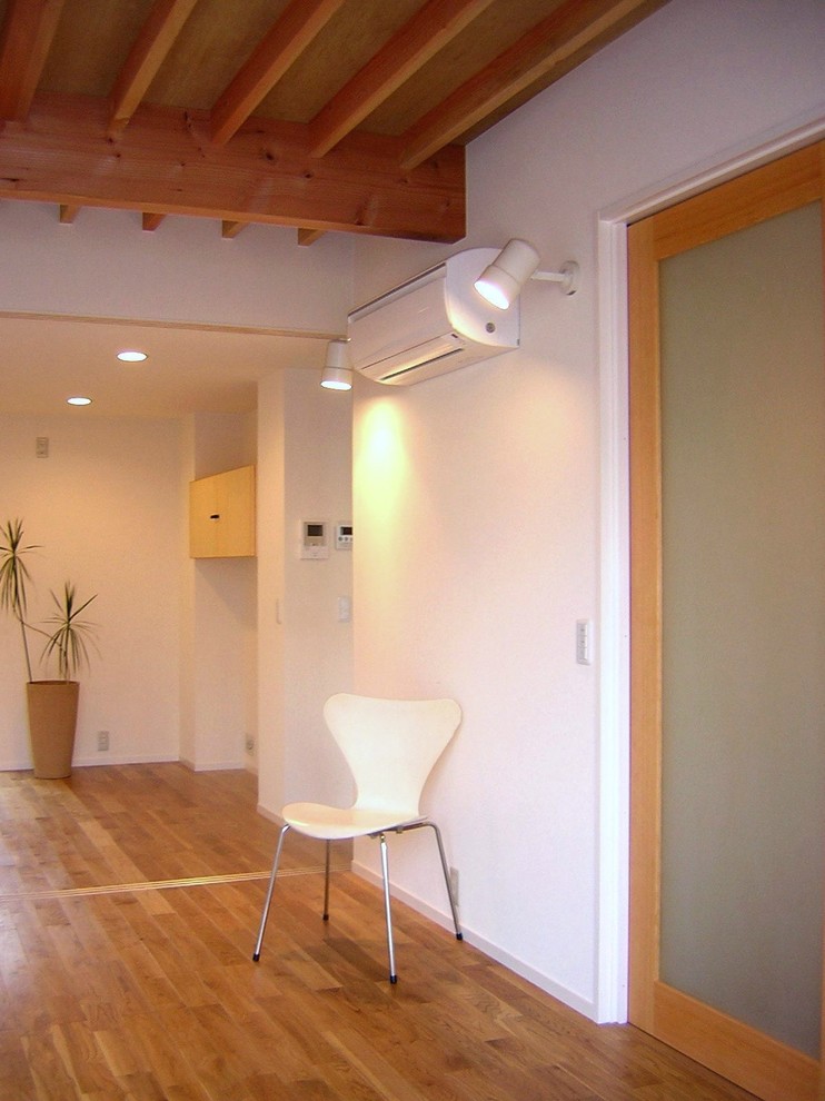 На фото: открытая гостиная комната среднего размера в стиле рустика с белыми стенами, паркетным полом среднего тона, отдельно стоящим телевизором и коричневым полом без камина с