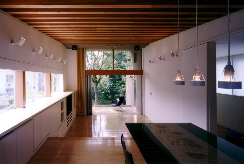 Идея дизайна: гостиная комната в стиле модернизм с белыми стенами, полом из фанеры, скрытым телевизором и бежевым полом