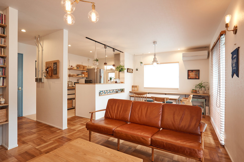 Bild på ett minimalistiskt vardagsrum, med vita väggar, mellanmörkt trägolv och brunt golv
