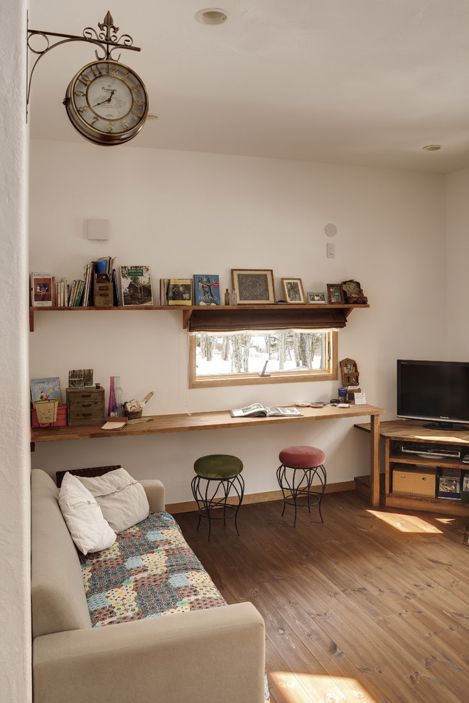 Idee per un soggiorno etnico con pareti bianche, pavimento in legno massello medio, TV autoportante e pavimento marrone