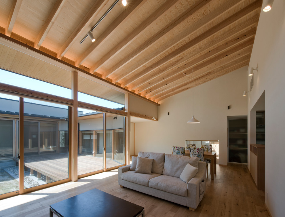 Foto di un soggiorno minimalista di medie dimensioni e aperto con pareti bianche, parquet chiaro e pavimento marrone