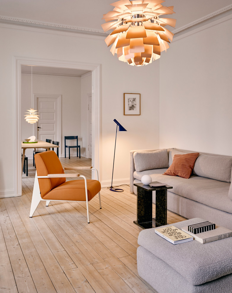 Cette photo montre un salon scandinave avec un mur blanc, parquet clair et un sol beige.