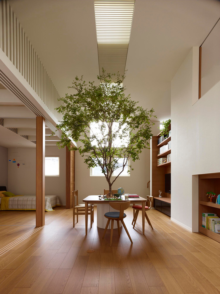 Imagen de salón abierto de estilo zen con paredes blancas, suelo de madera en tonos medios y televisor colgado en la pared