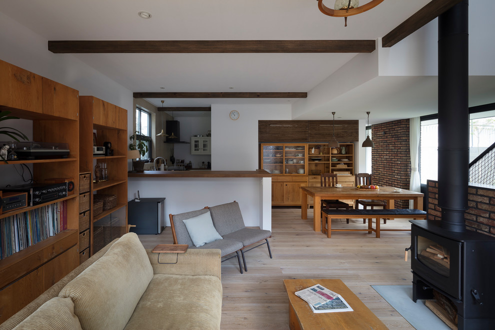 Idée de décoration pour un salon chalet ouvert avec un mur blanc, parquet clair et un sol beige.