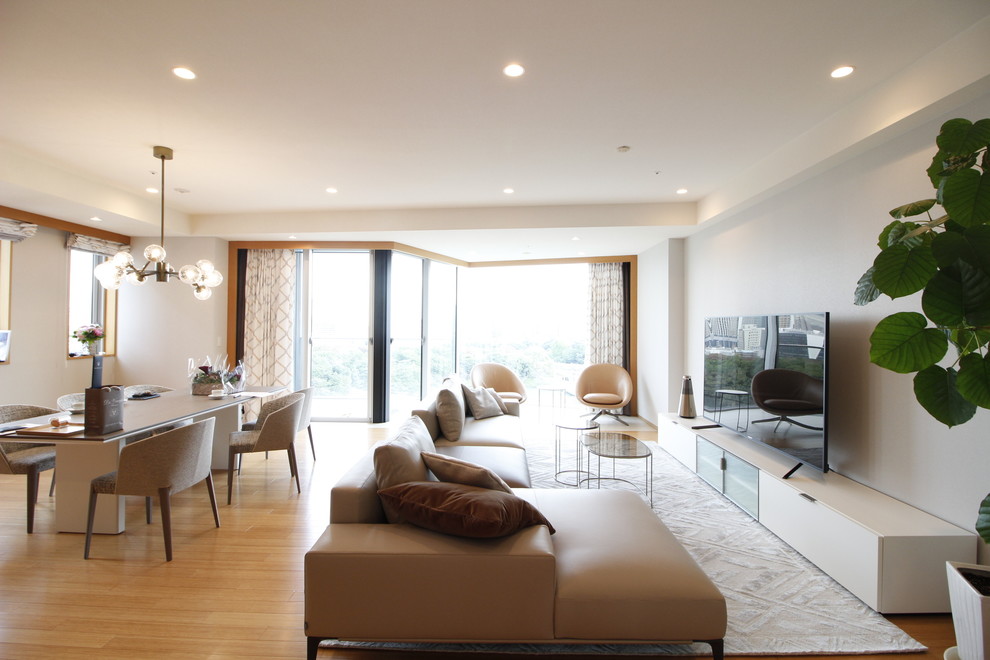 Foto di un grande soggiorno design aperto con pareti grigie, pavimento in bambù, nessun camino, TV autoportante e pavimento arancione