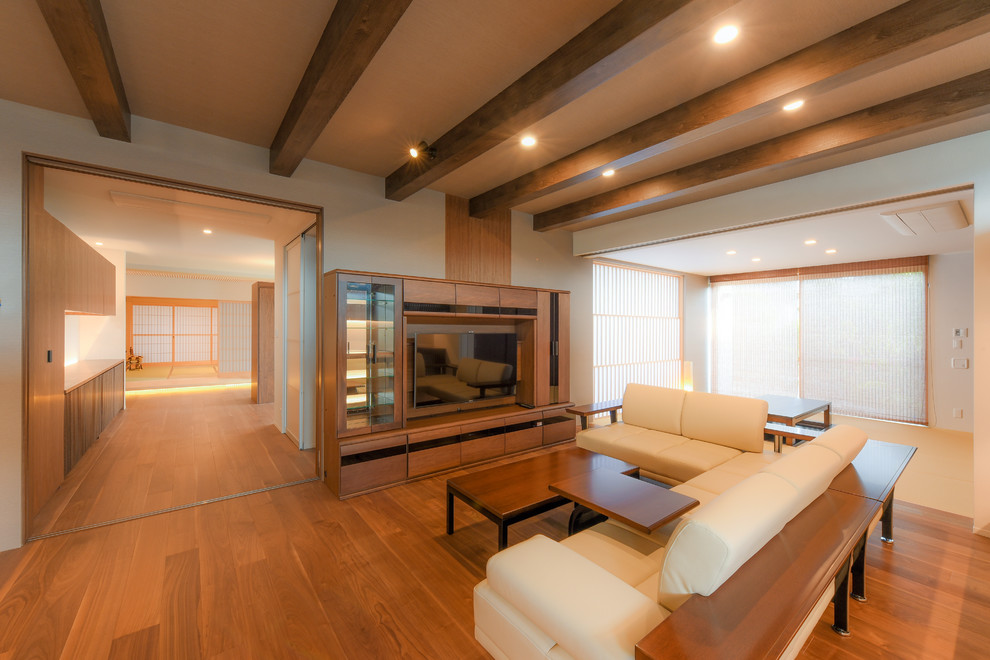 Asian medium tone wood floor and brown floor living room photo in Other with white walls, no fireplace and a wall-mounted tv