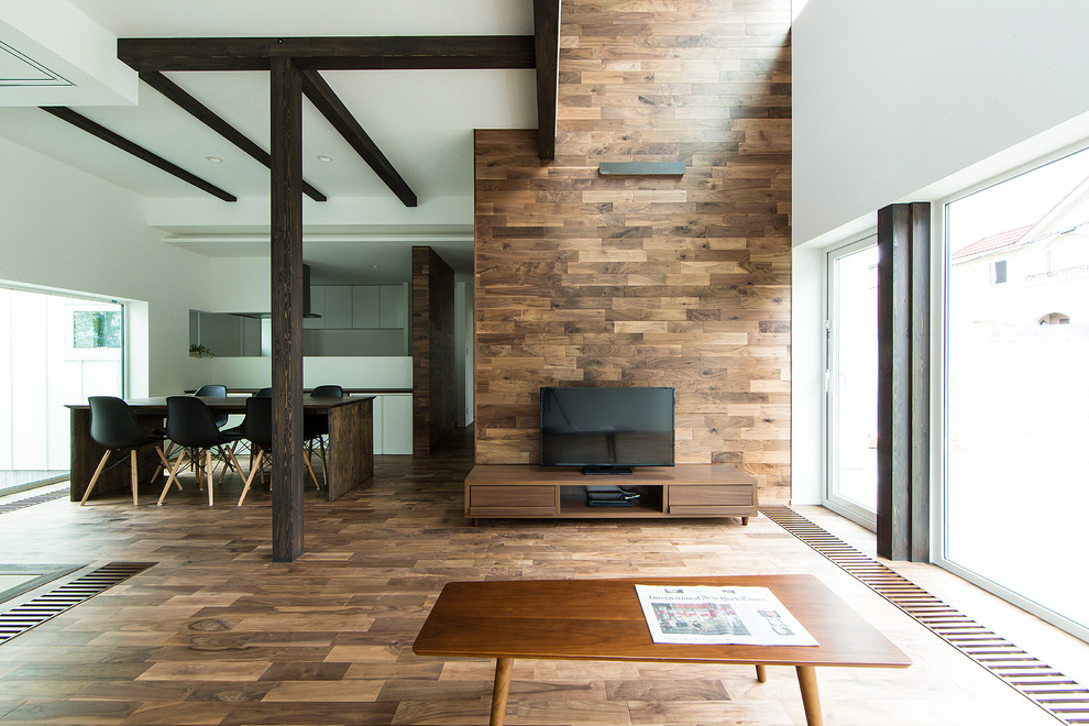 Offenes Modernes Wohnzimmer mit bunten Wänden, braunem Holzboden und freistehendem TV in Sapporo